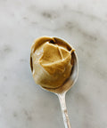 Spoonful of Sicilian pistachio cream on a marble surface