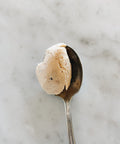 Spoonful of Sicilian almond cream made from Pizzuta d'Avola almonds on a marble surface