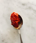 Spoonful of Calabrian hot pepper cream on a marble surface