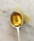 Spoonful of Sicilian extra virgin olive oil on a marble surface