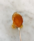 Spoonful of Sicilian orange blossom honey on a marble surface