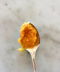 Spoonful of Sicilian blood orange marmalade on a marble surface