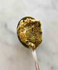 Spoonful of Sicilian pistachio pesto on a marble surface