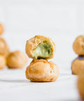 Pistachio cream filled cream puff piled on counter — Tutto Sicilia