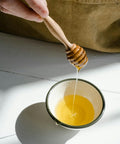 Orange blossom honey drizzled with jar on counter — Tutto Sicilia