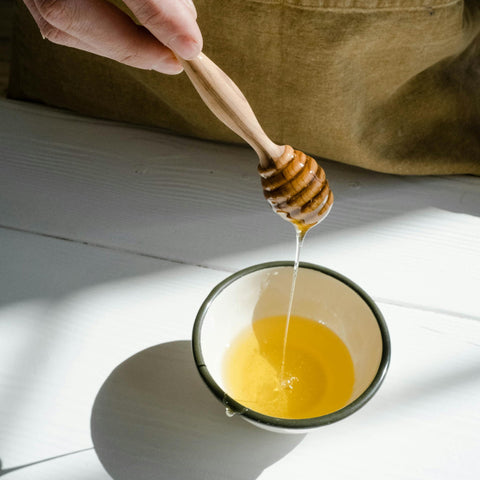Orange blossom honey drizzled with jar on counter — Tutto Sicilia