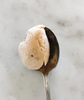 Spoonful of Sicilian almond cream made from Pizzuta d'Avola almonds on a marble surface