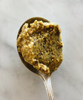 Spoonful of pistachio pesto, close-up on marble