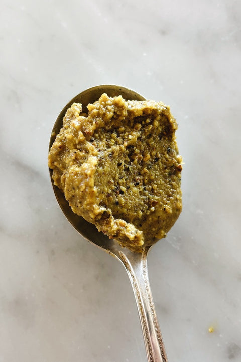 Spoonful of pistachio pesto, close-up on marble