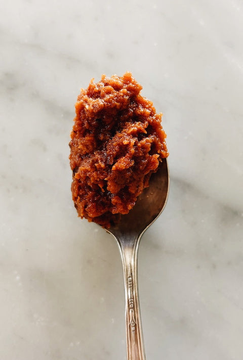 Spoonful of sun-dried tomato paté, close-up on marble